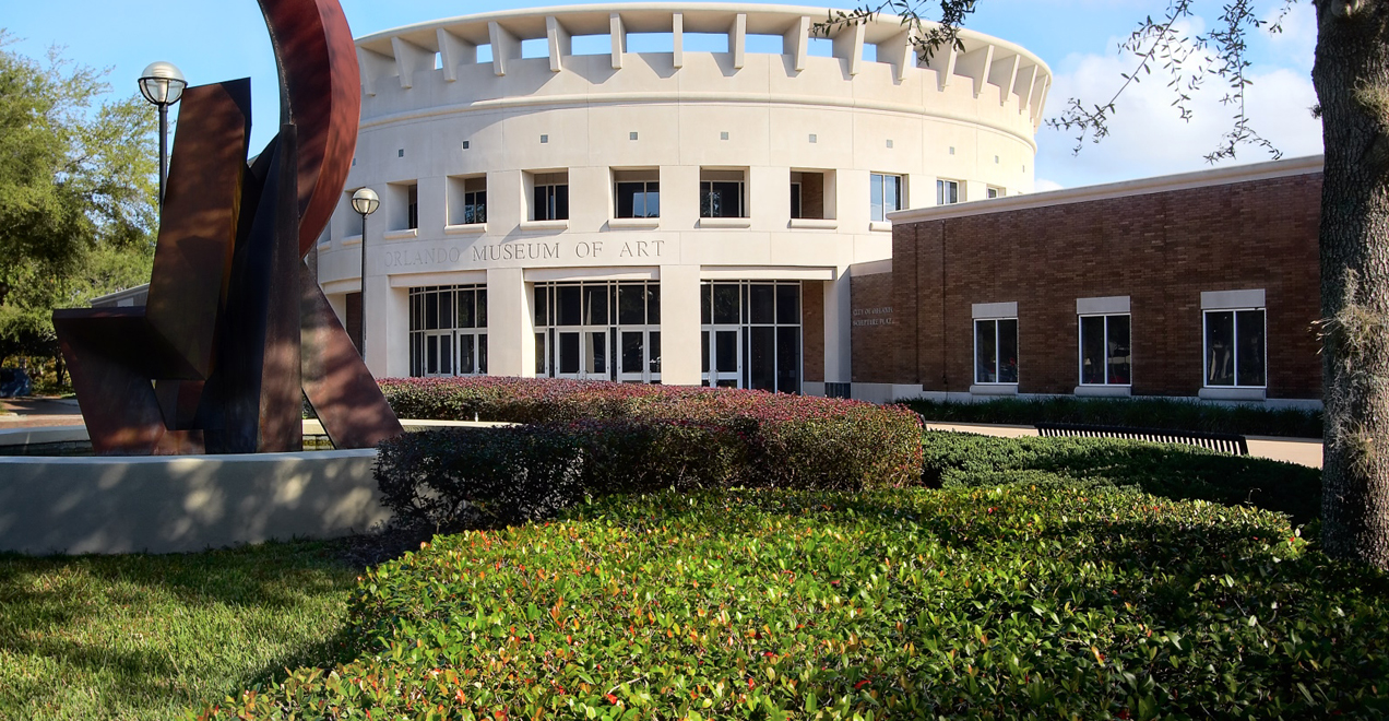 An outdoor view of the Orlando Museum of Art with a sculpture in view